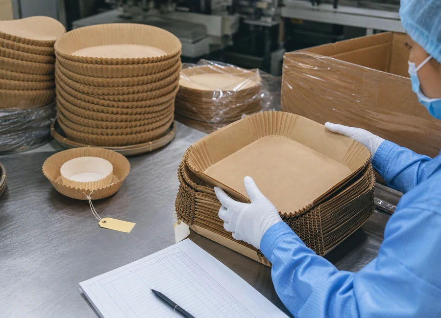 Worker inspecting air fryer paper liners