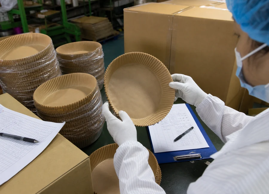 Worker inspecting air fryer paper liners