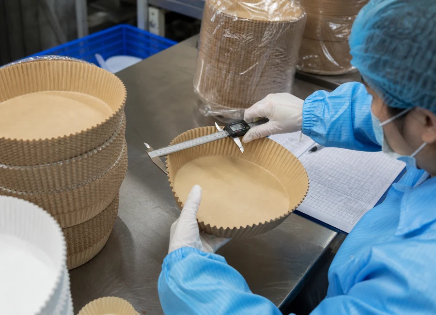 Worker inspecting air fryer paper liners