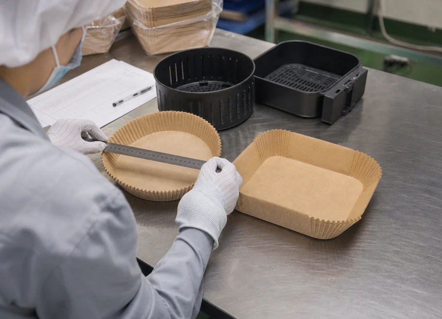 Worker inspecting air fryer paper liners