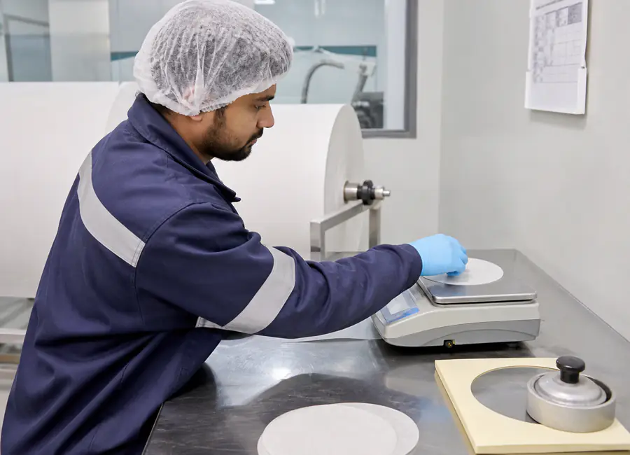 Worker inspecting food-contact paper reels