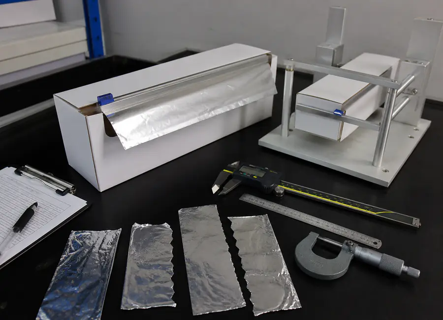 Chinese quality technician inspecting private label aluminum foil rolls