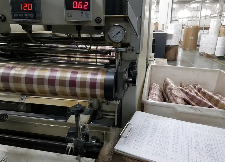 Chinese quality technician inspecting twist wrapping paper supplier